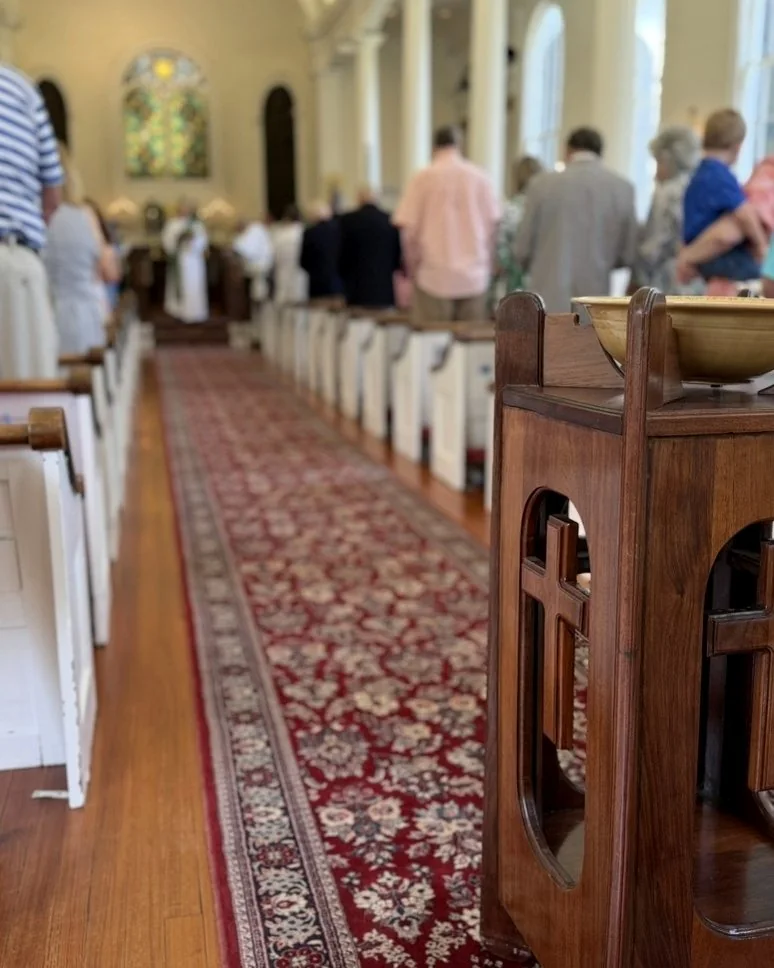 The center aisle of St. Paul’s during a Sunday service, running past a carved wooden font toward the altar.